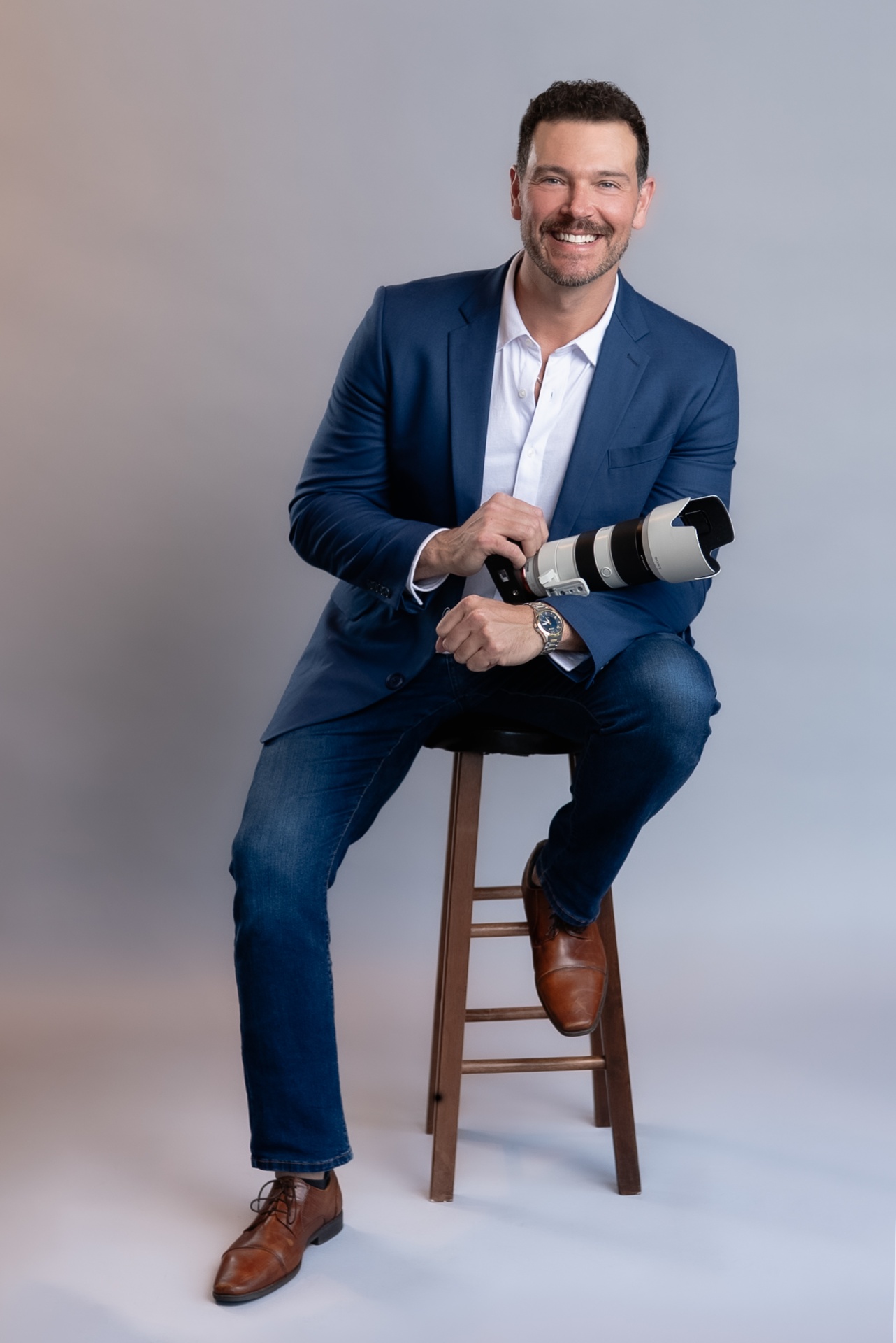 Greg, founder and lead cinematographer of Everlens Weddings, seated with his camera